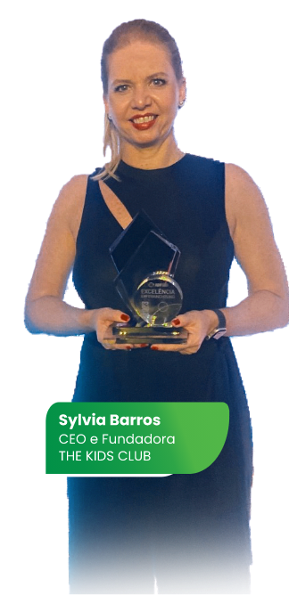 Mulher feliz, de vestido preto sem mangas, segurando um troféu em suas mãos. No final da imagem, tem um box verde com os cantos arredondados escrito Sylvia Barros, CEO e Fundadora CANALBR